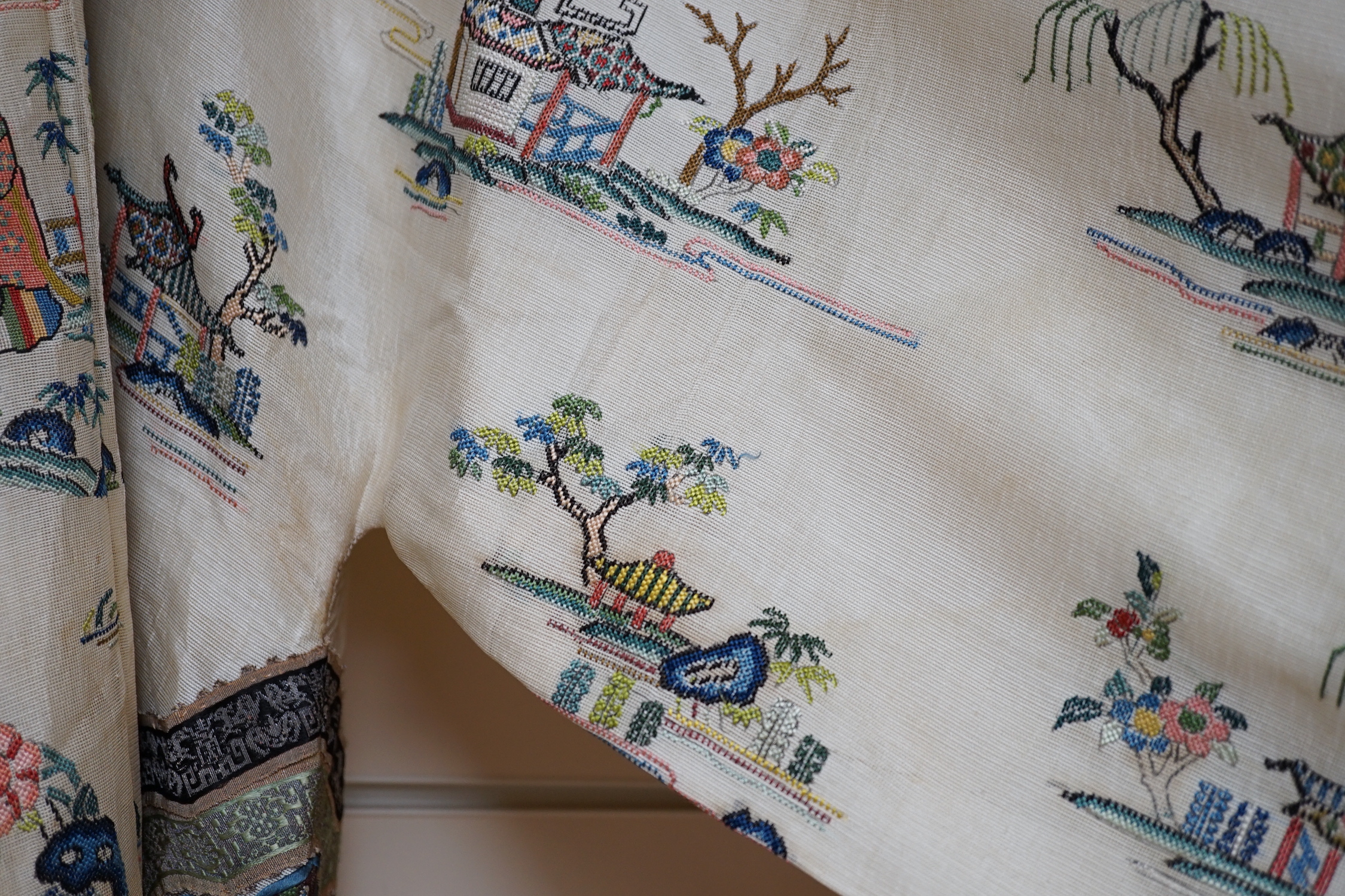A late 19th/early 20th century Chinese gauze summer robe embroidered with flowers, figures and pagodas, 85cm high